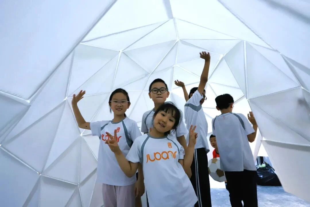 孩子们在自己搭建的穹顶结构中合影